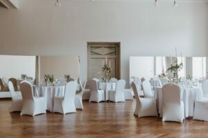 Okrągłe stoły w sali balowej z eleganckim zielonym wystrojem i dodatkami